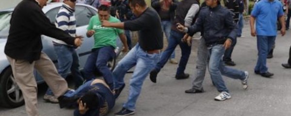 Policias de Arturo Bermudez vestidos de civil pateando a un profesor caido/ Foto cortesía AVC